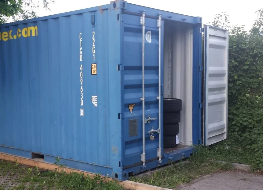 Geöffneter blauer Lagercontainer mit gestapelten eingelagerten Reifen